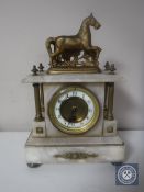 A brass and alabaster mantel clock with enamelled dial surmounted by a horse,