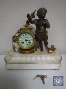 A continental gilt figural mantel clock of a cherub with enamelled dial on marble base