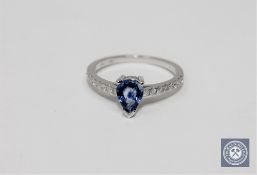 A 14ct white gold sapphire and diamond ring featuring one pear cut natural sapphire 0.
