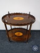 An oval Victorian inlaid mahogany tea trolley