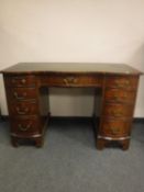 A reproduction mahogany serpentine fronted desk,