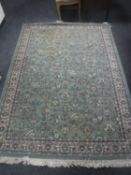 A fringed Old World Heritage Persian design rug on green ground