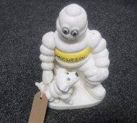 A cast metal figure of Michelin man with a dog