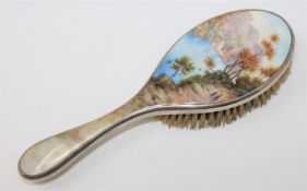 An antique silver and enamel dressing table brush depicting an alpine scene