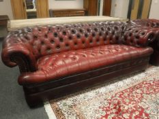 A red leather Chesterfield three seater settee,