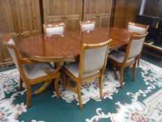 A Bradley inlaid yew wood twin-pedestal dining table with leaf and set of six chairs