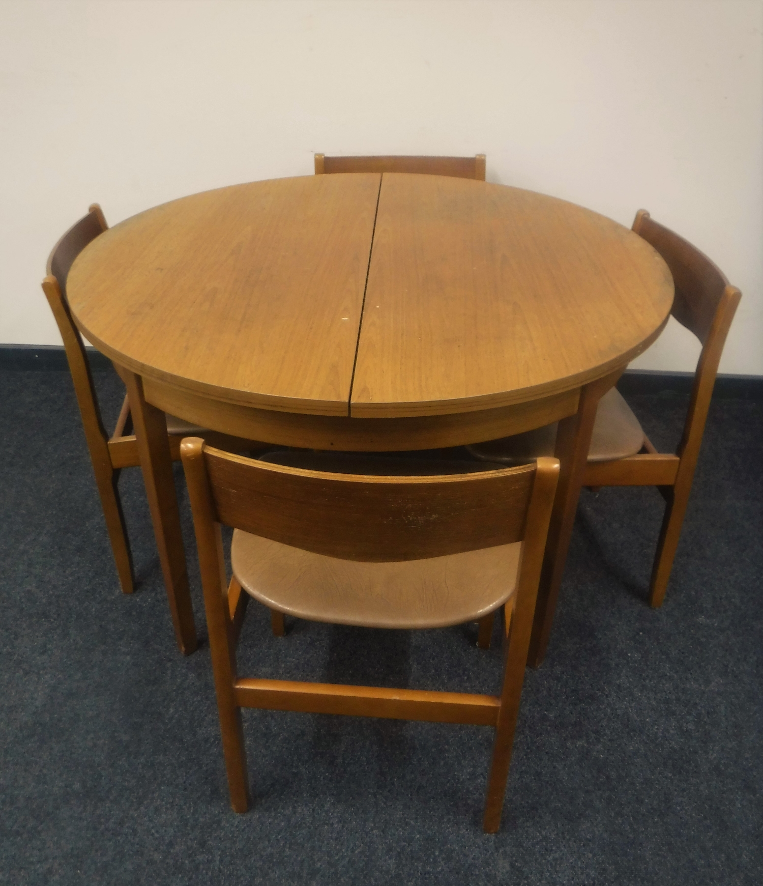 A circular 1970's teak extending dining table and four chairs