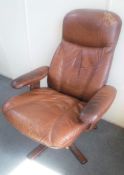 A late 20th century brown leather swivel armchair