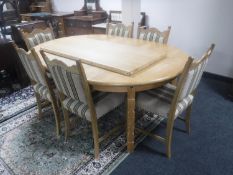 A blonde oak extending table with two leaves and six dining chairs