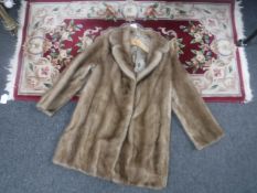 Fringed floral hearth rug together with a champagne mink fur coat