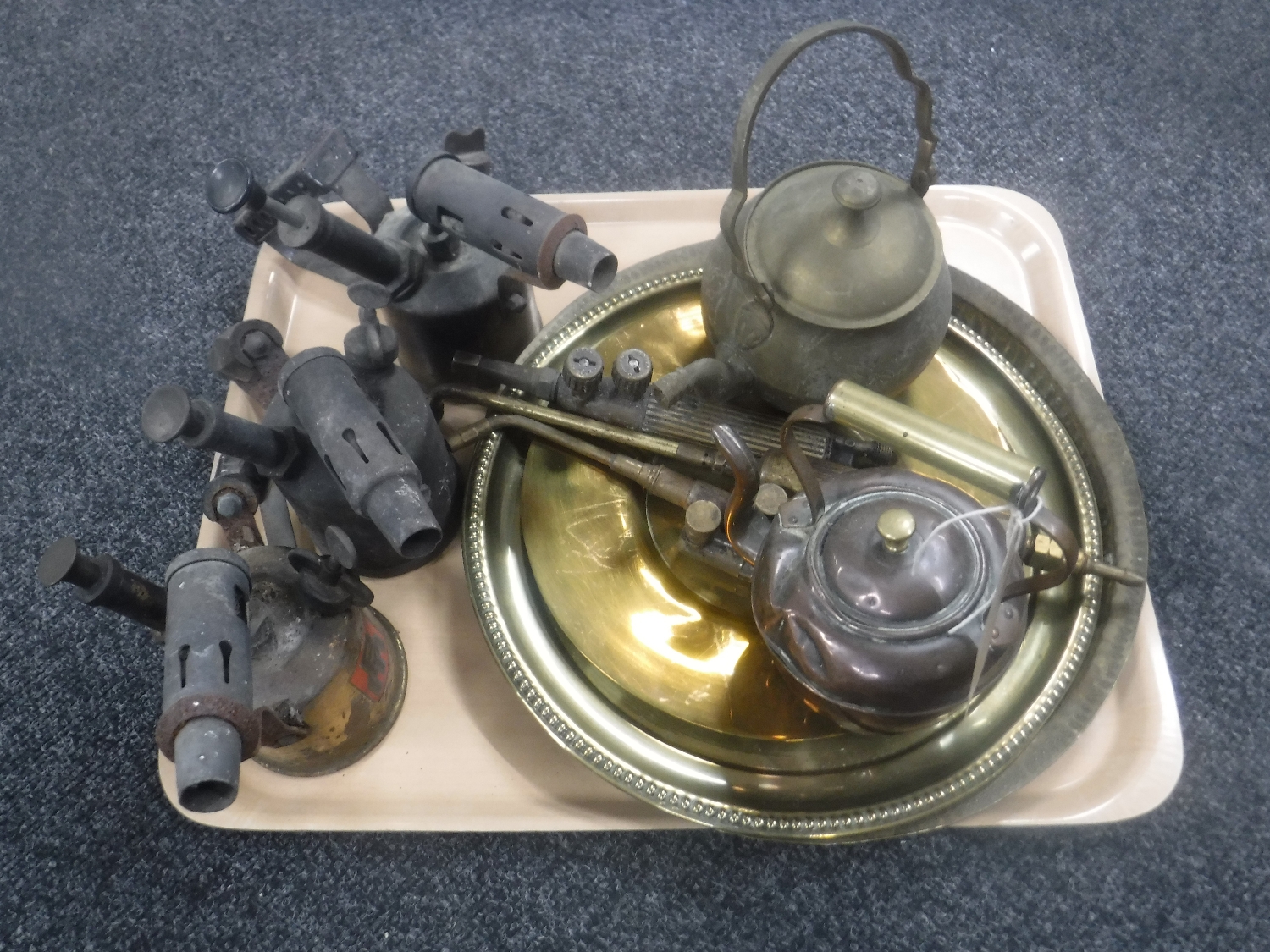 A tray of three vintage blow lamps, three brass plates, miniature teapot,