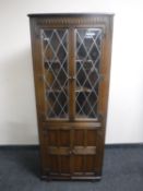 An oak leaded glass door corner display cabinet