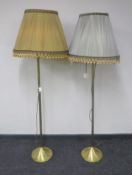 A pair of brass standard lamps with tasselled shades
