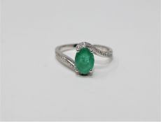 A 14ct white gold emerald and diamond ring featuring an oval cut emerald 1.