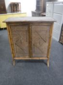 A 20th century bamboo and wicker double door cupboard