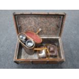 A miniature vintage travelling trunk containing leather cased military field glasses and two