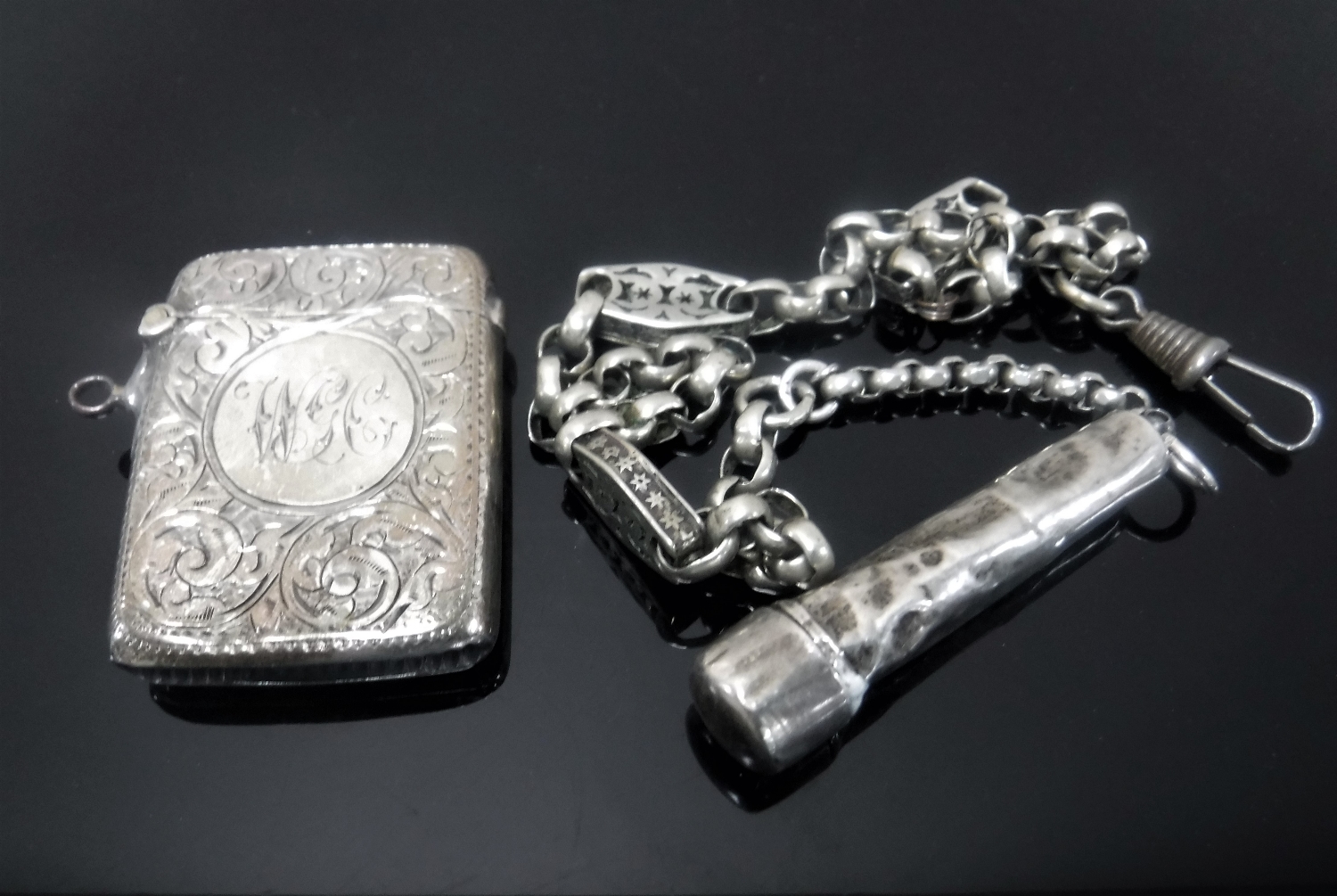 A silver vesta together with a belcher-link chain and a cheroot in case