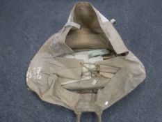 A WWII military issue camp bed in canvas bag