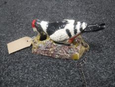 A cast metal woodpecker door knocker