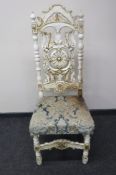 A heavily carved cream and gilt bedroom chair