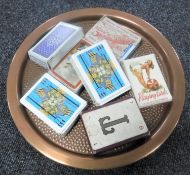 A circular copper tray together with seven sets of vintage playing cards