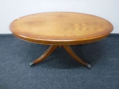 An oval inlaid yew wood pedestal coffee table,