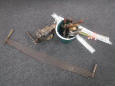 A heavy duty bench vice, vintage saw and bucket of hand tools,