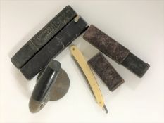 Three cut throat razors and a handle from a curling stone