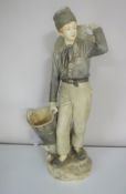 A continental pottery figure of a man carrying a basket