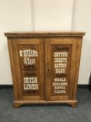 An Edwardian and later oak cabinet with advertising decoration, Irish Linen,