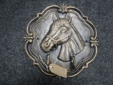 A cast metal wall plaque with two hooks