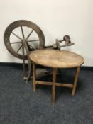A carved oak Arts & Crafts occasional table and a spinning wheel