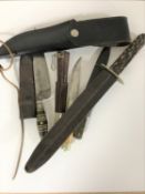 A stainless steel hunting knife in leather sheath and three further daggers