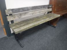 A metal and wooden slatted park style bench