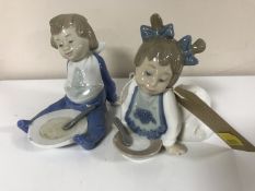Two Nao figures of babies with plates