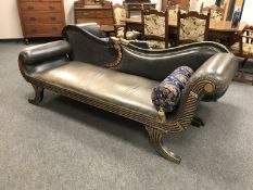 An Empire style studded leather scroll ended chaise with bolster cushion,