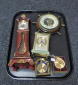 A tray of circular ship's wheel barometer, four assorted desk clocks,