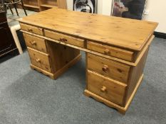 A pine twin pedestal desk fitted seven drawers