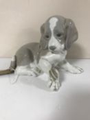 A Lladro figure of a puppy with snail on paw