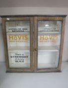 An antique pine double door wall cabinet painted with Hovis advertisement