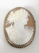 An antique cameo brooch depicting a maiden with flowers in her hair,