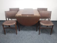 A Danish mahogany effect flap sided dining table with two leaves,