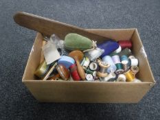 A box containing sewing equipment and threads