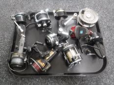 A tray containing ten assorted fixed spool and multiplier fishing reels including Abu Garcia
