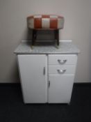 A mid 20th century kitchen cupboard and a leather footstool