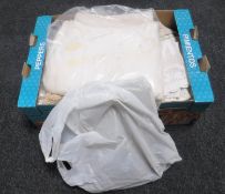 A box containing vintage table linen, two needlework panels,