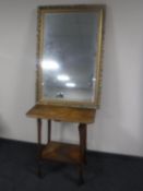 An oak Arts and Crafts occasional table and a gilt framed mirror