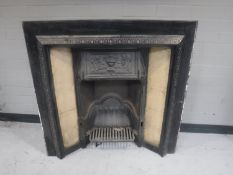 A Victorian cast iron fire with tiled panels