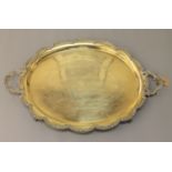 A heavy silver plated twin-handled tray, oval in shape with scalloped edge,