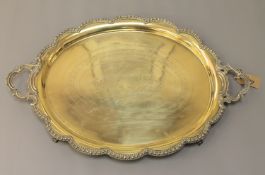 A heavy silver plated twin-handled tray, oval in shape with scalloped edge,